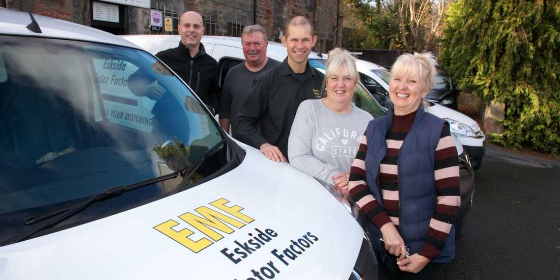 Eskside team standing next to a delivery van smiling and looking happy