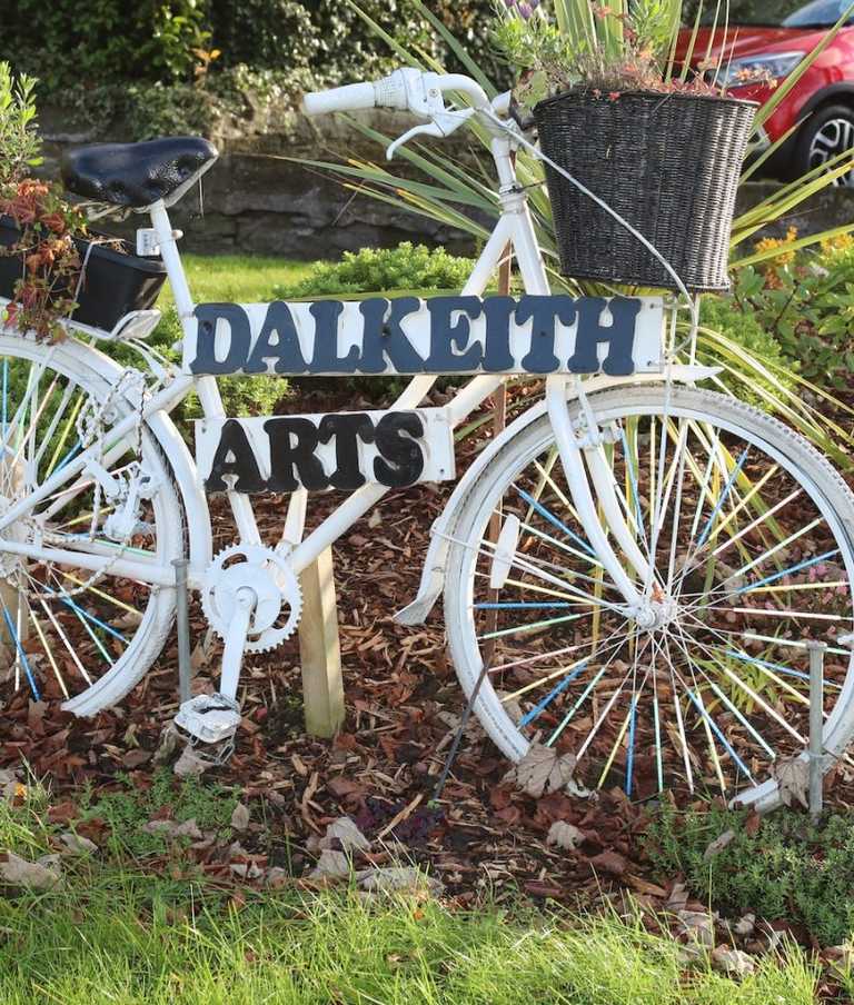 Bicycle in outside garden area with Dalkeith Arts written on it 